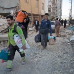 In this photo provided by Tasnim News Agency, people carry belongings after the earthquake at Sarpol-e-Zahab town in western Iran, Monday, Nov. 13, 2017. A powerful 7.3 magnitude earthquake that struck the Iraq-Iran border region killed more than three hundreds people in both countries, sent people fleeing their homes into the night and was felt as far west as the Mediterranean coast, authorities reported on Monday. (Farzad Menati/Tasnim News Agency via AP)
