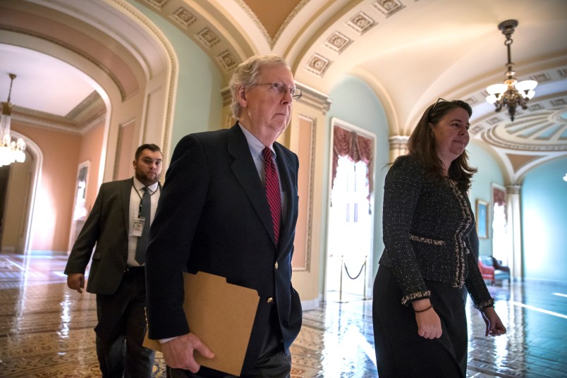 Senate Majority Leader Mitch McConnell, R-Ky., accompanied at right by Secretary for the Majority Laura Dove, walks to the chamber as  Republicans in the House and Senate plan to pass the sweeping $1.5 trillion GOP tax bill on party-line votes, at the Capitol in Washington, Monday, Dec. 18, 2017. (AP Photo/J. Scott Applewhite)