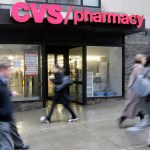 People walk past a CVS pharmacy in downtown Chicago Tuesday, March 18, 2008. On Tuesday, a settlement was announced in Chicago that Rhode Island-based CVS Caremark Corporation has agreed to pay almost $37 million to the federal government, 23 states and the District of Columbia to settle claims it billed Medicaid programs for a more expensive formulation of an antacid. The investigation began more than five years ago after a suburban Chicago pharmacist alerted authorities. (AP Photo/M. Spencer Green)
