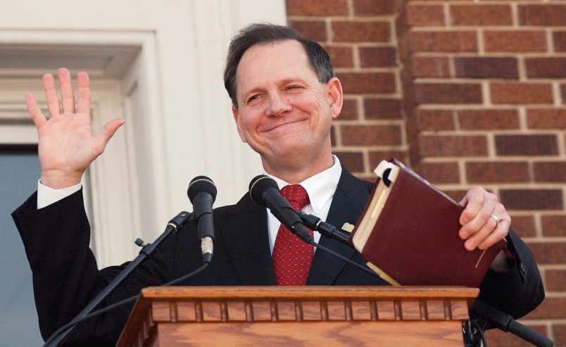 Former Alabama Chief Justice Roy Moore holds his bible as he acknowledges the applause during his speech at the Barrow County Court House in Winder, Ga., Thursday, Nov. 6, 2003. Moore drew rounds of applause as he spoke in support of the framed Ten Commandments in the courthouse breezeway. (AP Photo/Ric Feld)