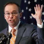 Mick Mulvaney holds up his hand as he speaks during a news conference after his first day as acting director of the Consumer Financial Protection Bureau in Washington, Monday, Nov. 27, 2017. (AP Photo/Jacquelyn Martin)