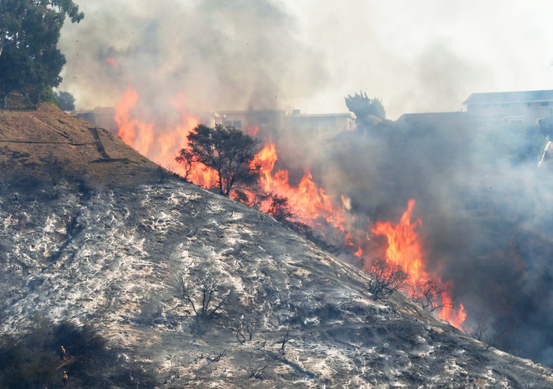 Flames sweep up a steep canyon wall, threatening homes on a ridgeline as the Skirball wildfire swept through the Bel Air district of Los Angeles Wednesday, Dec. 6, 2017. (AP Photo/Reed Saxon)