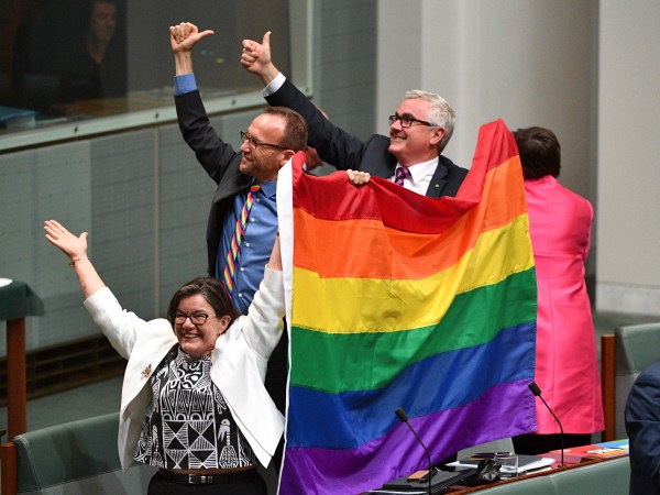 Members of parliament Cathy McGowan, Adam Brandt and Andrew Wilkie celebrate the passing of the Marriage Amendment Bill in the House of Representatives at Parliament House in Canberra, Thursday, Dec. 7, 2017. Gay marriage was endorsed by 62 percent of Australian voters who responded to a government-commissioned postal ballot by last month. (Mick Tsikas/AAP Image via AP)