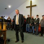 With friends and family standing behind him, Kentucky State Rep., Republican Dan Johnson addresses the public from his church on Tuesday, Dec. 12, 2017, regarding allegations that he sexually abused a teenager after a New Year's party in 2013, in Louisville, Ky. Johnson says a woman’s claim that he sexually assaulted her in 2013 has no merit and he will not resign. (AP Photo/Timothy D. Easley)