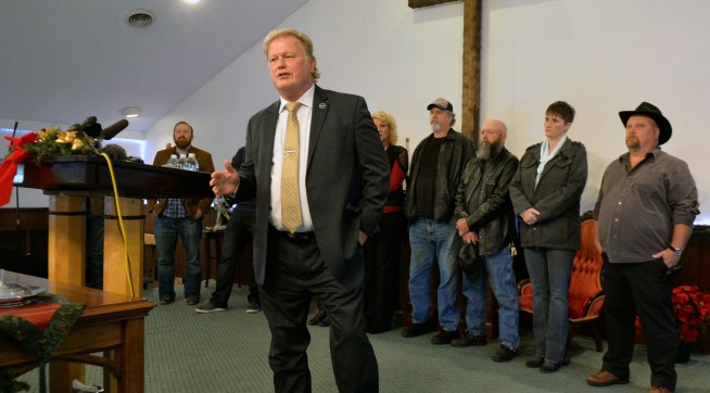 With friends and family standing behind him, Kentucky State Rep., Republican Dan Johnson addresses the public from his church on Tuesday, Dec. 12, 2017, regarding allegations that he sexually abused a teenager after a New Year's party in 2013, in Louisville, Ky. Johnson says a woman’s claim that he sexually assaulted her in 2013 has no merit and he will not resign. (AP Photo/Timothy D. Easley)