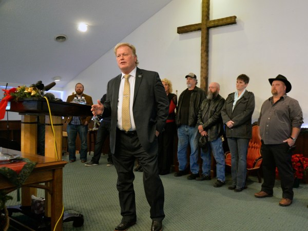With friends and family standing behind him, Kentucky State Rep., Republican Dan Johnson addresses the public from his church on Tuesday, Dec. 12, 2017, regarding allegations that he sexually abused a teenager after a New Year's party in 2013, in Louisville, Ky. Johnson says a woman’s claim that he sexually assaulted her in 2013 has no merit and he will not resign. (AP Photo/Timothy D. Easley)