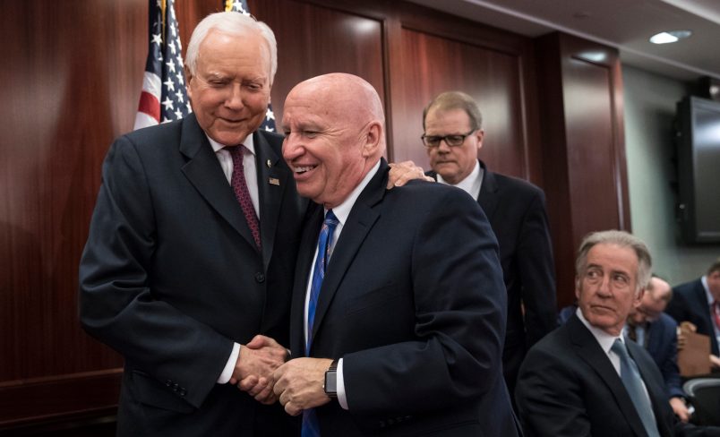 House Ways and Means Committee Chairman Kevin Brady, R-Texas, center, embraces Senate Finance Committee Chairman Orrin Hatch, R-Utah, left, as House and Senate conferees after GOP leaders announced they have forged an agreement on a sweeping overhaul of the nation's tax laws, on Capitol Hill in Washington, Wednesday, Dec. 13, 2017. Rep. Richard Neal, D-Mass., ranking member of the House Ways and Means Committee, looks on at far right. Democrats objected to the bill and asked that a final vote be delayed until Senator-elect Doug Jones of Alabama is seated. (AP Photo/J. Scott Applewhite)