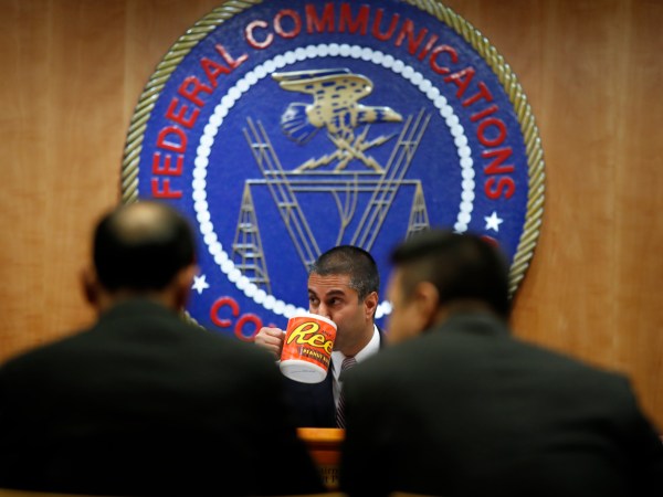 Federal Communications Commission (FCC) Chairman Ajit Pai takes a drink from a mug during introductions during an FCC meeting where they will vote on net neutrality, Thursday, Dec. 14, 2017, in Washington. (AP Photo/Jacquelyn Martin)