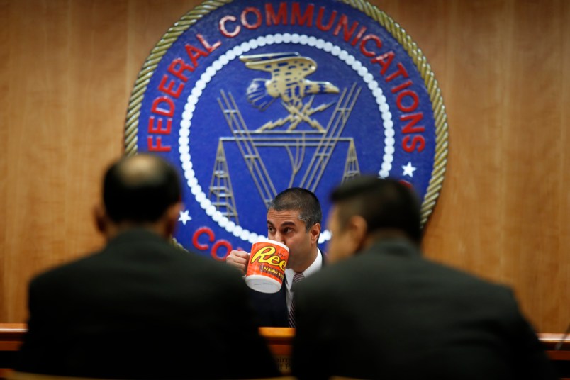 Federal Communications Commission (FCC) Chairman Ajit Pai takes a drink from a mug during introductions during an FCC meeting where they will vote on net neutrality, Thursday, Dec. 14, 2017, in Washington. (AP Photo/Jacquelyn Martin)