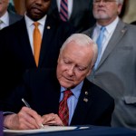Senate Finance Committee Chairman Orrin Hatch, R-Utah, signs the final version of the GOP tax bill during an enrollment ceremony at the Capitol in Washington, Thursday, Dec. 21, 2017. (AP Photo/Andrew Harnik)