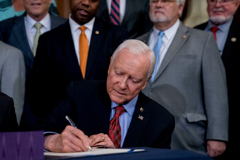 Senate Finance Committee Chairman Orrin Hatch, R-Utah, signs the final version of the GOP tax bill during an enrollment ceremony at the Capitol in Washington, Thursday, Dec. 21, 2017. (AP Photo/Andrew Harnik)