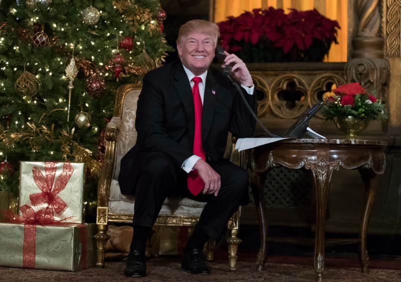 President Donald Trump smiles to the media as he speaks on the phone with children as they track Santa's movements with the North American Aerospace Defense Command (NORAD)  Santa Tracker on Christmas Eve at the president's Mar-a-Lago estate in Palm Beach, Fla., Sunday, Dec. 24, 2017. (AP Photo/Carolyn Kaster)