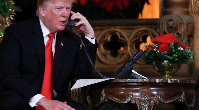 President Donald Trump speaks on the phone with children as they track Santa's movements with the North American Aerospace Defense Command (NORAD)  Santa Tracker on Christmas Eve at the president's Mar-a-Lago estate in Palm Beach, Fla., Sunday, Dec. 24, 2017. (AP Photo/Carolyn Kaster)
