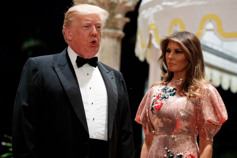 First lady Melania Trump looks on as President Donald Trump speaks with reporters after arriving for a New Year's Eve gala at his Mar-a-Lago resort, Sunday, Dec. 31, 2017, in Palm Beach, Fla. (AP Photo/Evan Vucci)