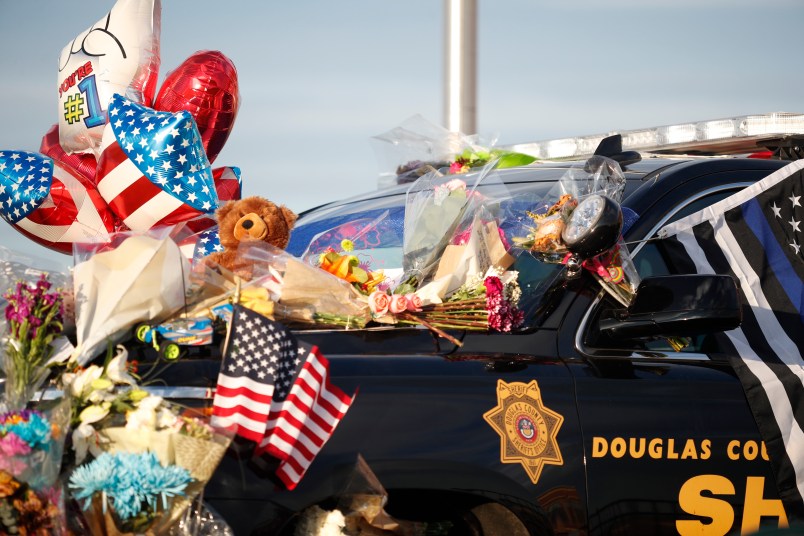 Tributes to a deputy killed in a shootout cover a patrol vehicle parked outside a Douglas County, Colo., Sheriffs Department substation Monday, Jan. 1, 2018, in Highlands Ranch, Colo. The deputy was killed and four other deputies were shot while responding to a call at a nearby apartment complex early Sunday. (AP Photo/David Zalubowski)