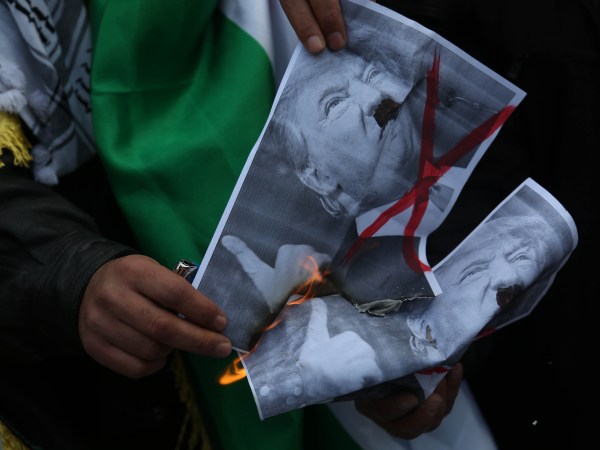 Palestinians burn posters depicting U.S. President Donald Trump and a U.S. flag and Israeli flag during a protest against Trump's decision to recognize Jerusalem as the capital of Israel, in Gaza City on January 15, 2018. (Photo by Majdi Fathi/NurPhoto)