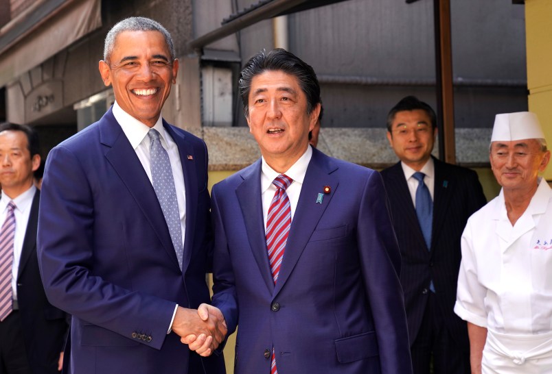 Former U.S. President Barack Obama and Japanese Prime Minister Shinzo Abe pose for photographers in front of Japanese Sushi restaurant in Tokyo's Ginza shopping district, Sunday, March 25, 2018. (AP Photo/Shizuo Kambayashi, Pool)