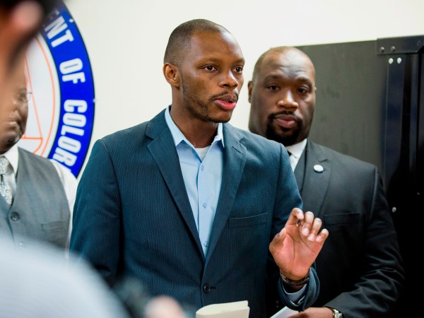 FILE - In this June 5, 2017, file photo, Arizona state Democratic Rep. Reginald Bolding Jr., left, calls on Gov. Doug Ducey to remove six confederate monuments in Arizona during a news conference by the NAACP and Black Lives Matter in Phoenix, Ariz. Bolden successfully pushed for changes in the state's driving rules that inform gun-carrying motorists how they should handle themselves if they get pulled over by police officers. (AP Photo/Angie Wang, File)