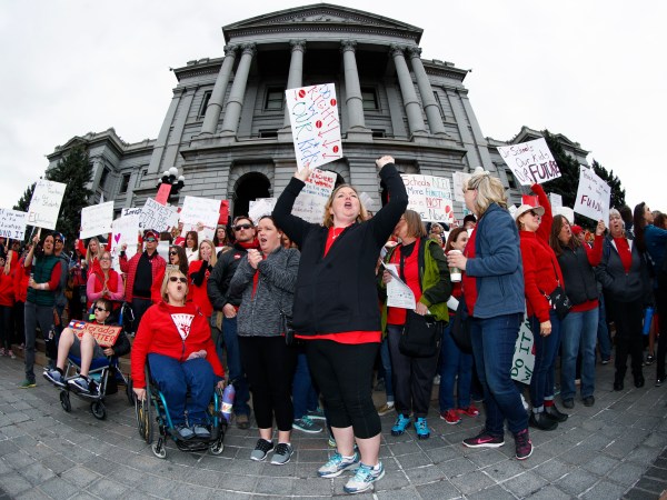 As viewed through a fisheye lens, Stephanie Rolf, a teacher in the Douglas County, Colo., school system, leads a cheer during a teacher rally Thursday, April 26, 2018, in Denver. More than 10,000 teachers in Colorado are expected to demonstrate as part of a burgeoning teacher uprising from the East to the interior West that is demanding more tax dollars be spent in public schools. (AP Photo/David Zalubowski)