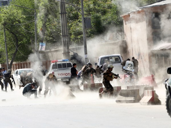 Security forces run from the site of a suicide attack one frame after the second deadly attack in Kabul, Afghanistan, Monday, April 30, 2018.  (AP Photo/Massoud Hossaini)