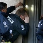 ROWLAND HEIGHTS, CA. - MARCH 3: Immigration and Customs Enforcement (ICE) agents from the Department of Homeland Security look into the window of an apartment while executing search warrants during an ongoing investigation of alleged birth tourism centers on March 3, 2015 in Rowland Heights, California. Agents from multiple federal and local law enforcement agencies executed search warrants in Orange, Los Angeles and San Bernardino counties on Tuesday morning. (Photo by Mark Boster/Los Angeles Times via Getty Images)