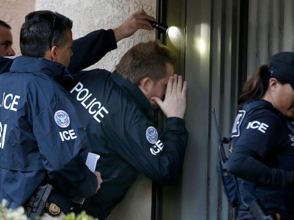 ROWLAND HEIGHTS, CA. - MARCH 3: Immigration and Customs Enforcement (ICE) agents from the Department of Homeland Security look into the window of an apartment while executing search warrants during an ongoing investigation of alleged birth tourism centers on March 3, 2015 in Rowland Heights, California. Agents from multiple federal and local law enforcement agencies executed search warrants in Orange, Los Angeles and San Bernardino counties on Tuesday morning. (Photo by Mark Boster/Los Angeles Times via Getty Images)