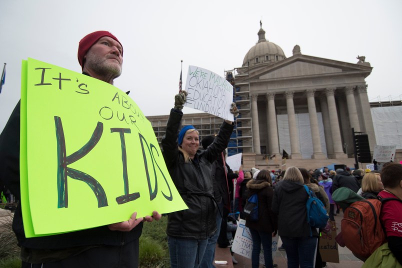 OKLAHOMA CITY, OK - APRIL 2:  Kent Scott, a teacher from Tecumseh, Okla. holds a protest sign at the state capitol in Oklahoma City, Oklahoma on April 2, 2018. Thousands of teachers and supporters are scheduled to rally Monday at the state Capitol as Oklahoma becomes the latest state to be plagued by teacher strife. Teachers are walking off the job after a $6,100 pay raise was rushed through the Legislature and signed into law by Gov. Mary Fallin. (Photo by J Pat Carter/Getty Images)