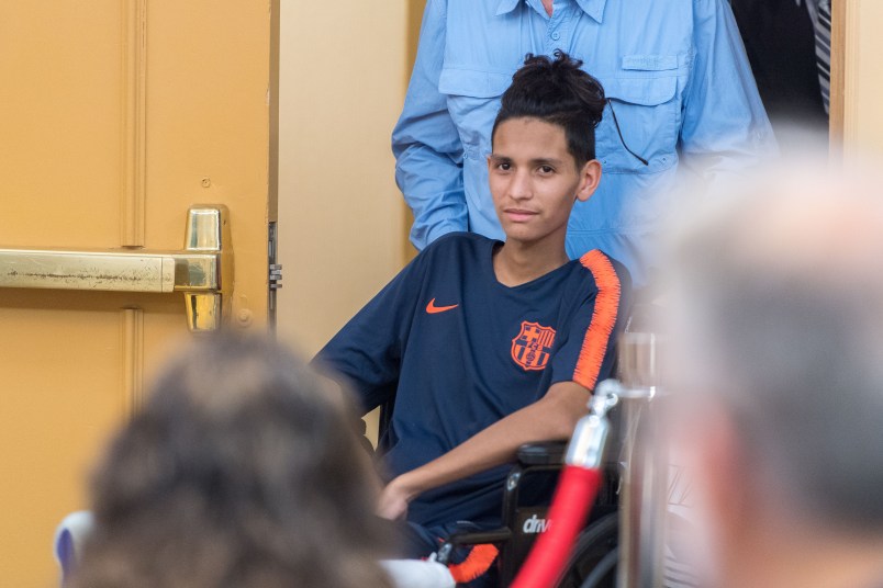 Anthony Borges, 15, who was shot five times on February 14th in the Marjory Stoneman Douglas massacre, is helped into a news conference by his grandfather at the Sheraton Suites Plantation on Friday, April 6, 2018, in Plantation, Fla. Still recovering after he used his body as a human shield to protect the lives of his fellow classmates, he was not able to speak during the conference. (Jennifer Lett/Sun Sentinel/TNS)