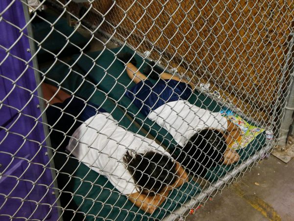 Two female detainees sleep in a holding cell, as the children are separated by age group and gender, as hundreds of mostly Central American immigrant children are being processed and held at the U.S. Customs and Border Protection Nogales Placement Center on Wednesday, June 18, 2014, in Nogales, Ariz.  CPB provided media tours Wednesday of two locations in Brownsville, Texas, and Nogales, that have been central to processing the more than 47,000 unaccompanied children who have entered the country illegally since Oct. 1. (AP Photo/Ross D. Franklin, Pool)