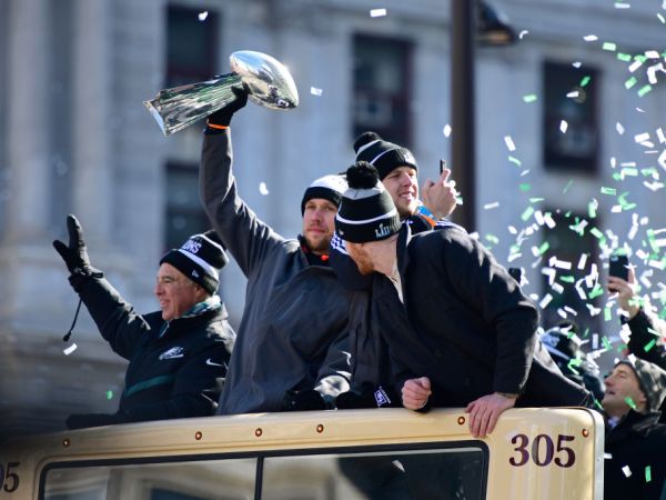 PHILADELPHIA, PA - FEBRUARY 08: (L-R) Team owner Jeffrey Lurie, with quarterbacks Nick Foles #9, Nate Sudfeld #7 and Carson Wentz #11 of the Philadelphia Eagles, acknowledge fans as Foles hoists the Vince Lombardi Trophy atop a parade bus during festivities on February 8, 2018 in Philadelphia, Pennsylvania. The city celebrated the Philadelphia Eagles' Super Bowl LII championship with a victory parade. (Photo by Corey Perrine/Getty Images)