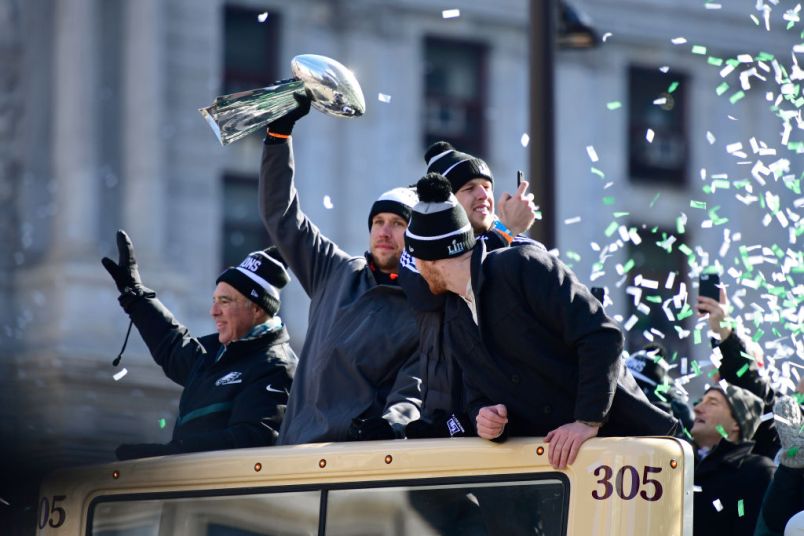 PHILADELPHIA, PA - FEBRUARY 08: (L-R) Team owner Jeffrey Lurie, with quarterbacks Nick Foles #9, Nate Sudfeld #7 and Carson Wentz #11 of the Philadelphia Eagles, acknowledge fans as Foles hoists the Vince Lombardi Trophy atop a parade bus during festivities on February 8, 2018 in Philadelphia, Pennsylvania. The city celebrated the Philadelphia Eagles' Super Bowl LII championship with a victory parade. (Photo by Corey Perrine/Getty Images)