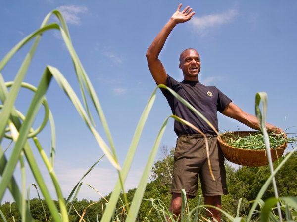 WINTHROP, ME - JUNE 30: Maine legislator, farmer and fierce advocate for Maine's sustainability movement, Craig Hickman waves to a neighbor while picking garlic scapes on his Annabessacook Farm in Winthrop. (Photo by Carl D. Walsh/Staff Photographer)