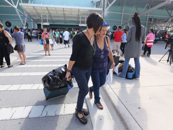 Wanda Collazo escorts her mother Marta Collazo from the arrival area as she departs the Adventure of the Seas after being evacuated from her apartment in Puerto Rico. (Emily Michot/Miami Herald/TNS)