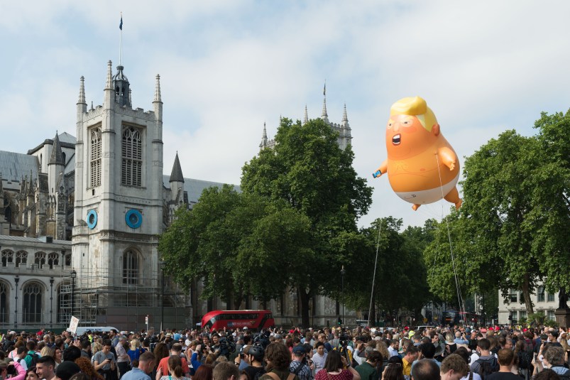 LONDON, UNITED KINGDOM - JULY 13: A 20-feet tall "Trump Baby" baloon depicting the US president as an angry orange infant with a smartphone, flies above Parliament Square in central London. Donald Trump and first lady Melania are due to meet the Queen today as part of their three-day working visit to the UK. July 13, 2018 in London, England.
