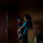 SAN RAFAEL LAS FLORES, GUATEMALA - JULY, 17: Elvia Mariela Marroquin, 31, who is Ervin's mother, hold her younger son Dylan, 2, inside the kitchen in her house in Las Nueces village, Santa Rosa.Otto Albizurez, 27, and his son Ervin, 10, left their home of Las Nueces village of San Rafael Las Flores, Santa Rosa, Guatemala, on Abril 28, 2018, heading to the USA. After three weeks travelling through Mexico, they were deteined in McAllen, Texas, by the border patrols. They were together for the first three day and than they were separated, detained in two different places. Otto spent 10 more days in a jail and than was deported to Guatemala. His son, Ervin is still in USA, in a shelter of Houston, Texas. (Photo by Daniele Volpe for The Washington Post)