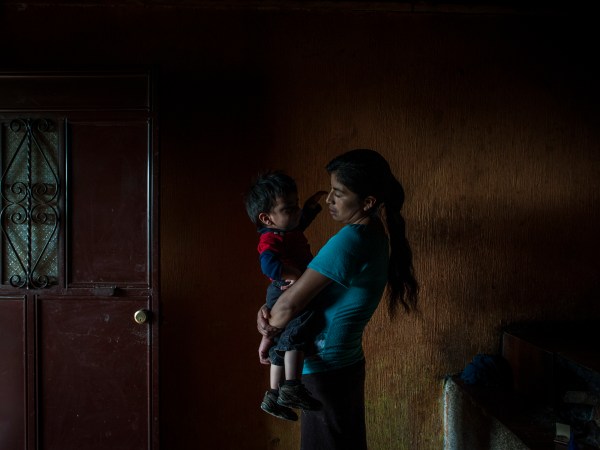 SAN RAFAEL LAS FLORES, GUATEMALA - JULY, 17: Elvia Mariela Marroquin, 31, who is Ervin's mother, hold her younger son Dylan, 2, inside the kitchen in her house in Las Nueces village, Santa Rosa.Otto Albizurez, 27, and his son Ervin, 10, left their home of Las Nueces village of San Rafael Las Flores, Santa Rosa, Guatemala, on Abril 28, 2018, heading to the USA. After three weeks travelling through Mexico, they were deteined in McAllen, Texas, by the border patrols. They were together for the first three day and than they were separated, detained in two different places. Otto spent 10 more days in a jail and than was deported to Guatemala. His son, Ervin is still in USA, in a shelter of Houston, Texas. (Photo by Daniele Volpe for The Washington Post)