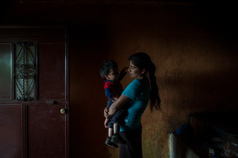 SAN RAFAEL LAS FLORES, GUATEMALA - JULY, 17: Elvia Mariela Marroquin, 31, who is Ervin's mother, hold her younger son Dylan, 2, inside the kitchen in her house in Las Nueces village, Santa Rosa.Otto Albizurez, 27, and his son Ervin, 10, left their home of Las Nueces village of San Rafael Las Flores, Santa Rosa, Guatemala, on Abril 28, 2018, heading to the USA. After three weeks travelling through Mexico, they were deteined in McAllen, Texas, by the border patrols. They were together for the first three day and than they were separated, detained in two different places. Otto spent 10 more days in a jail and than was deported to Guatemala. His son, Ervin is still in USA, in a shelter of Houston, Texas. (Photo by Daniele Volpe for The Washington Post)