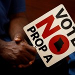 ** HOLD FOR USE WITH STORY BY DAVID LIEB ** In this photo taken Tuesday, July 31, 2018, people opposing Proposition A listen to a speaker during a rally in Kansas City, Mo. Missouri votes Tuesday on a so-called right-to-work law, a voter referendum seeking to ban compulsory union fees in all private-sector workplaces. (AP Photo/Charlie Riedel)