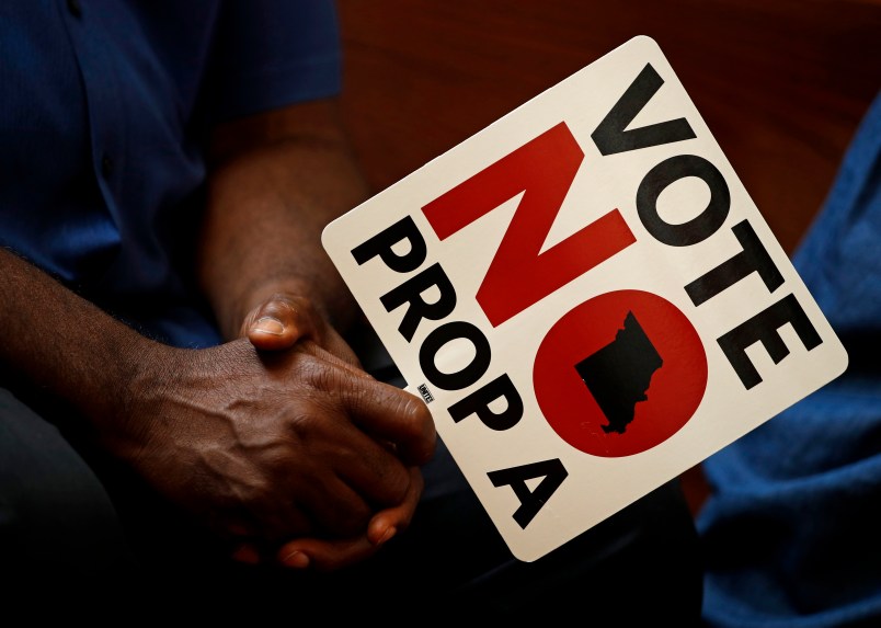** HOLD FOR USE WITH STORY BY DAVID LIEB ** In this photo taken Tuesday, July 31, 2018, people opposing Proposition A listen to a speaker during a rally in Kansas City, Mo. Missouri votes Tuesday on a so-called right-to-work law, a voter referendum seeking to ban compulsory union fees in all private-sector workplaces. (AP Photo/Charlie Riedel)