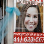 A poster for missing University of Iowa student Mollie Tibbetts hangs in the window of a local business, Tuesday, Aug. 21, 2018, in Brooklyn, Iowa. Tibbetts was reported missing from her hometown in the eastern Iowa city of Brooklyn in July 2018. (AP Photo/Charlie Neibergall)