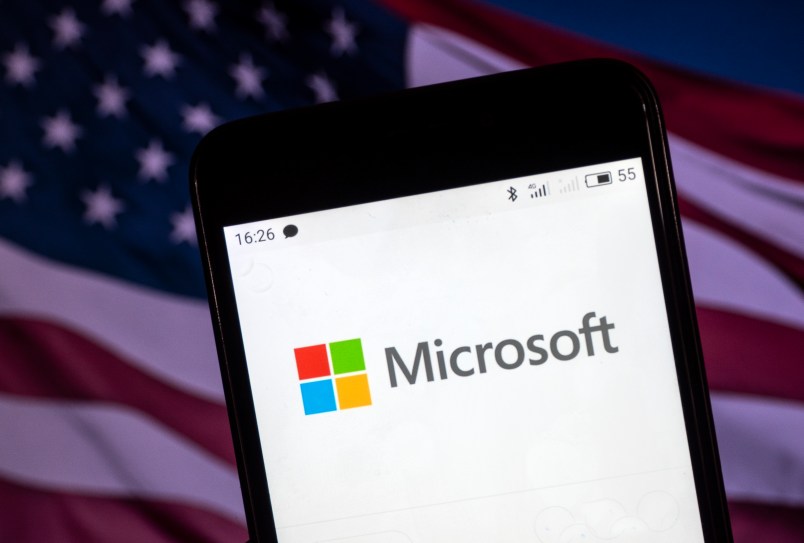 KIEV, UKRAINE - 2018/08/06: The Microsoft logo seen displayed on a smart phone with a background of an American Flag. According to the New York Stock Exchange (NYSE), the company is on the fourth place at the market value in the world - $ 825.8 billion. (Photo by Igor Golovniov/SOPA Images/LightRocket via Getty Images)