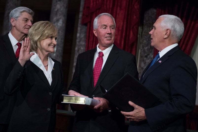 UNITED STATES - APRIL 9: Sen. Cindy Hyde-Smith, R-Miss., participates in her swearing-in ceremony the Capitol's Old Senate Chamber with Vice President Mike Pence, right, and her husband Michael, after being sworn in on the Senate floor on April 9, 2018. Mississippi Gov. Phil Bryant appears at left. (Photo By Tom Williams/CQ Roll Call)
