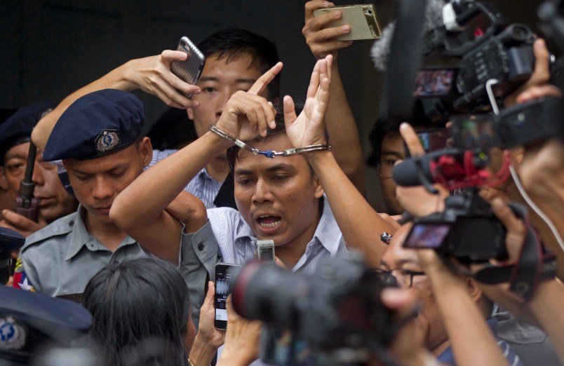 Reuters journalist Kyaw Soe Oo, center, talks to journalists during he is escorted by polices as they leave the court Monday, Sept. 3, 2018, in Yangon, Myanmar. (AP Photo/Thein Zaw)