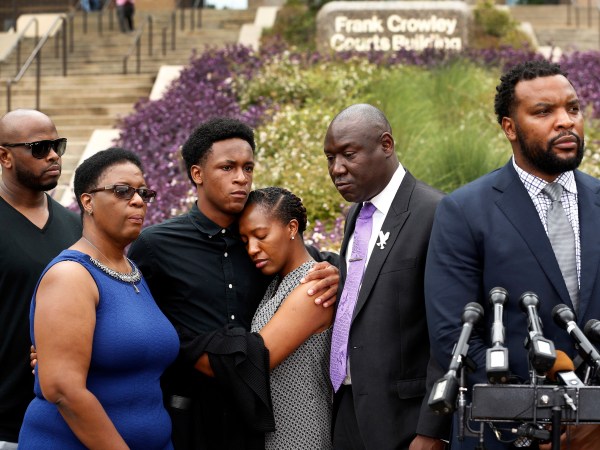Brandt Jean, brother of shooting victim Botham Jean (third from left), hugs his sister Allisa Findley, during a press conference outside the Frank Crowley Courts Building in reference to the shooting of Jean by Dallas police officer Amber Guyger, Monday, September 10, 2018. He was joined by his mother, Allison Jean (left) and attorney Benjamin Crump (second from right). Their attorney Lee Merritt (right) speaks to the media. (Tom Fox/The Dallas Morning News)