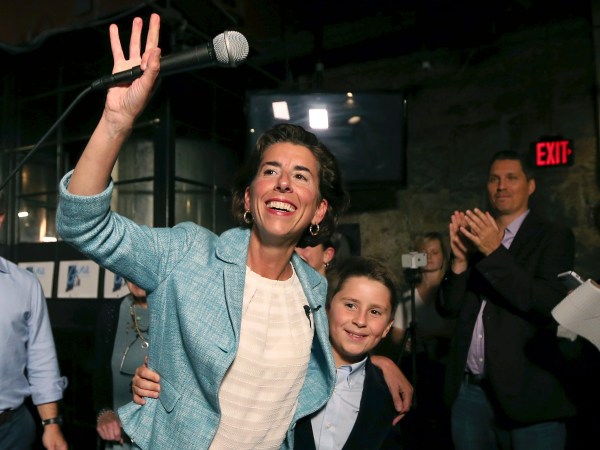 Incumbent Democratic Rhode Island Gov. Gina Raimondo waves to supporters, alongside her son, Thompson, at her primary night victory party, Wednesday, Sept. 12, 2018, in Providence, R.I. (AP Photo/Elise Amendola)