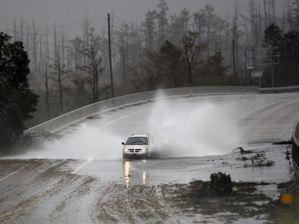 A car drives through water on U.S. 74/76 in Leland, N.C., Saturday, September 15, 2018. The rain from Hurricane Florence was expected to continue through Sunday.         [Matt Born/StarNews Photo]