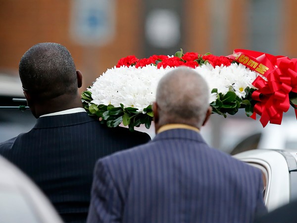 RICHARDSON, TX - SEPTEMBER 13: A person carrying a wreath of flowers walks through the parking lot at the Greenville Avenue Church of Christ for the funeral service for Botham Shem Jean on September 13, 2018 in Richardson, Texas. Jean was killed when a Dallas Police officer who accidentally went into Jean's apartment, thinking it was her own and shot him. (Photo by Stewart  F. House/Getty Images)