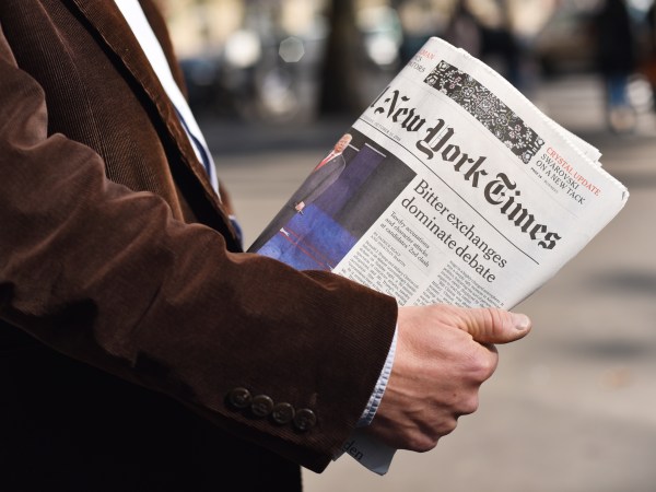 Man holding the New York Times in his hand