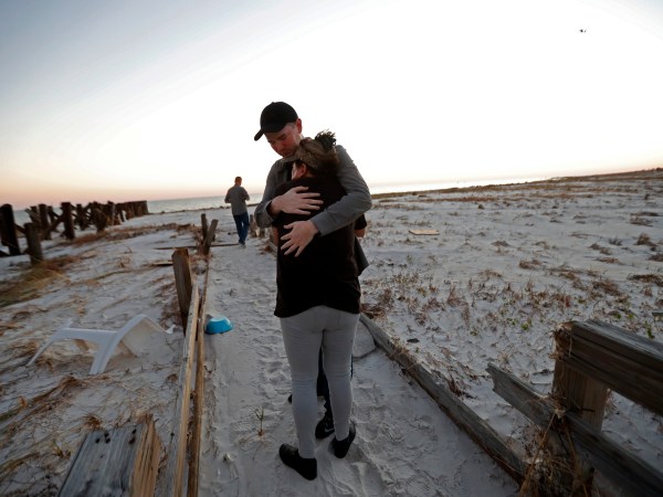 Matthew Fortner hugs his mother Lavonia Fortner, as they walk to view the beach for what they feel is the last time, after they sifted through the rubble of her father-in-laws destroyed home, in the aftermath of Hurricane Michael in Mexico Beach, Fla., Saturday, Oct. 13, 2018. John E. Fortner, not pictured, a Mexico Beach resident, came with his family to find memorabilia his wife collected, which is now scattered amidst the rubble of his obliterated home. (AP Photo/Gerald Herbert)