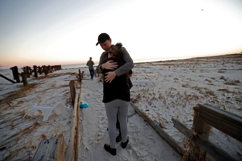 Matthew Fortner hugs his mother Lavonia Fortner, as they walk to view the beach for what they feel is the last time, after they sifted through the rubble of her father-in-laws destroyed home, in the aftermath of Hurricane Michael in Mexico Beach, Fla., Saturday, Oct. 13, 2018. John E. Fortner, not pictured, a Mexico Beach resident, came with his family to find memorabilia his wife collected, which is now scattered amidst the rubble of his obliterated home. (AP Photo/Gerald Herbert)